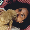 amina cuddling her teddy bear in bed